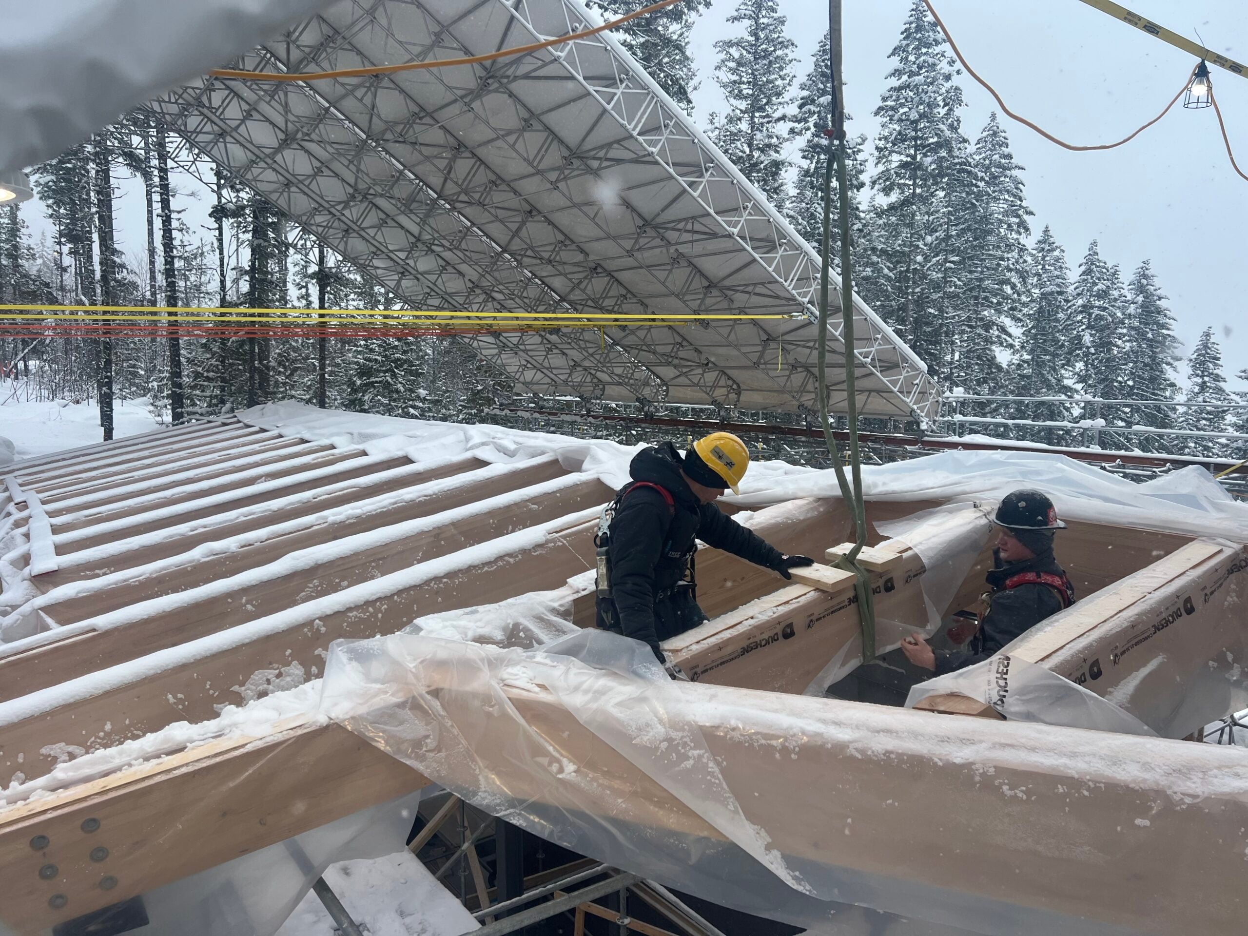 Workers working on roofing during winter construction.