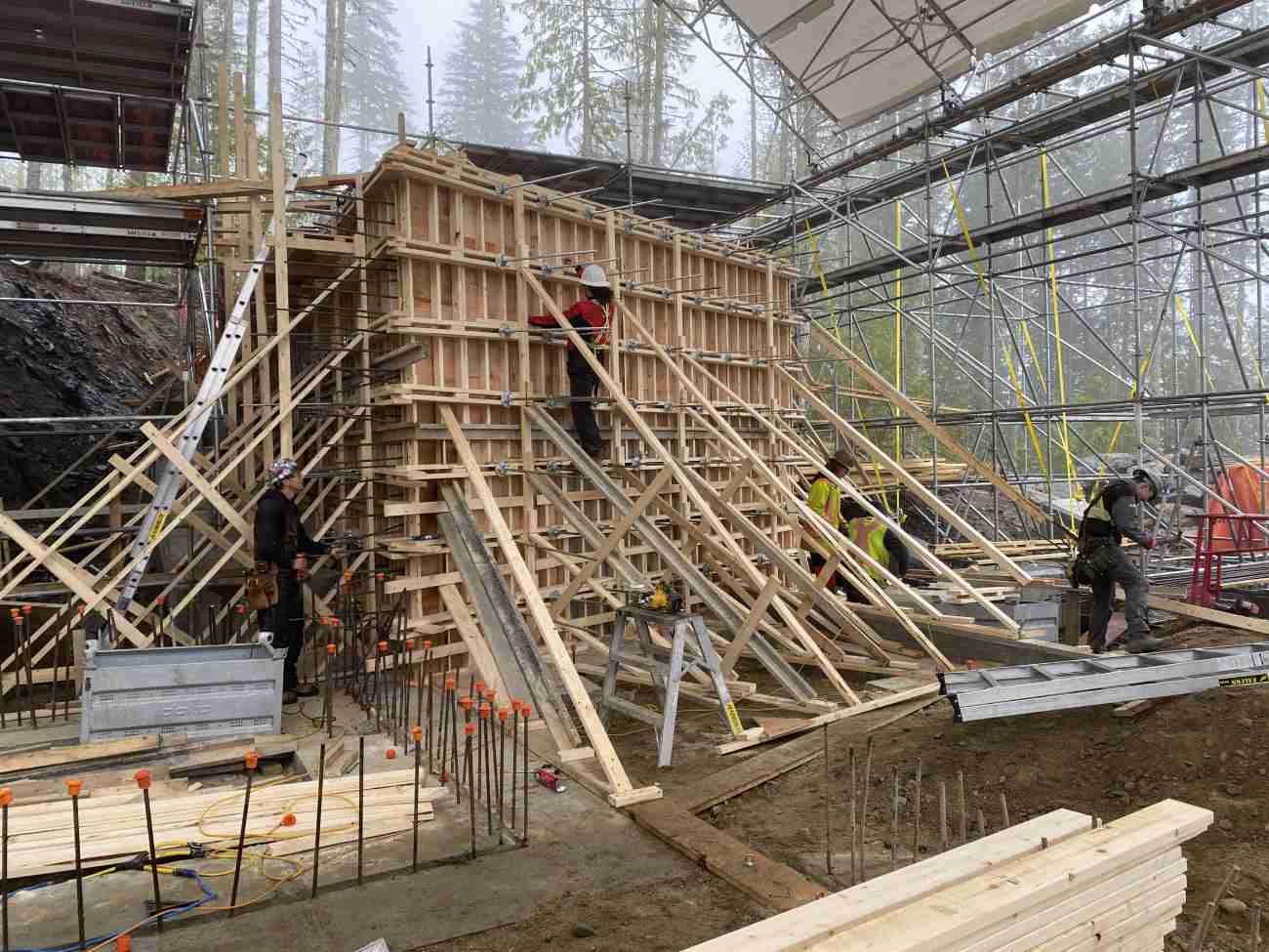 Construction workers putting up scaffolding as part of seasonal project planning.